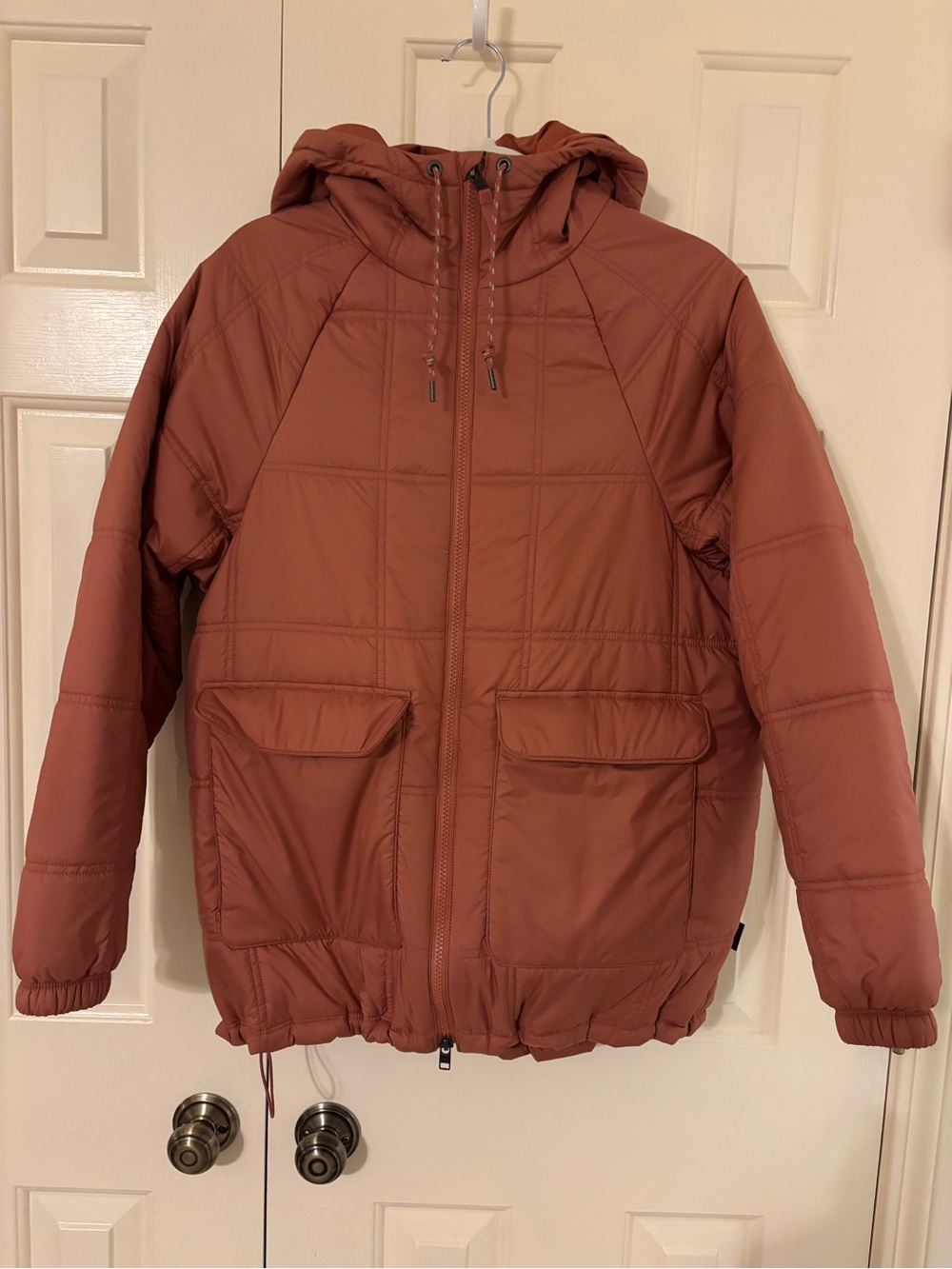 Patagonia Women’s Hooded Puffer Jacket in a light rust color